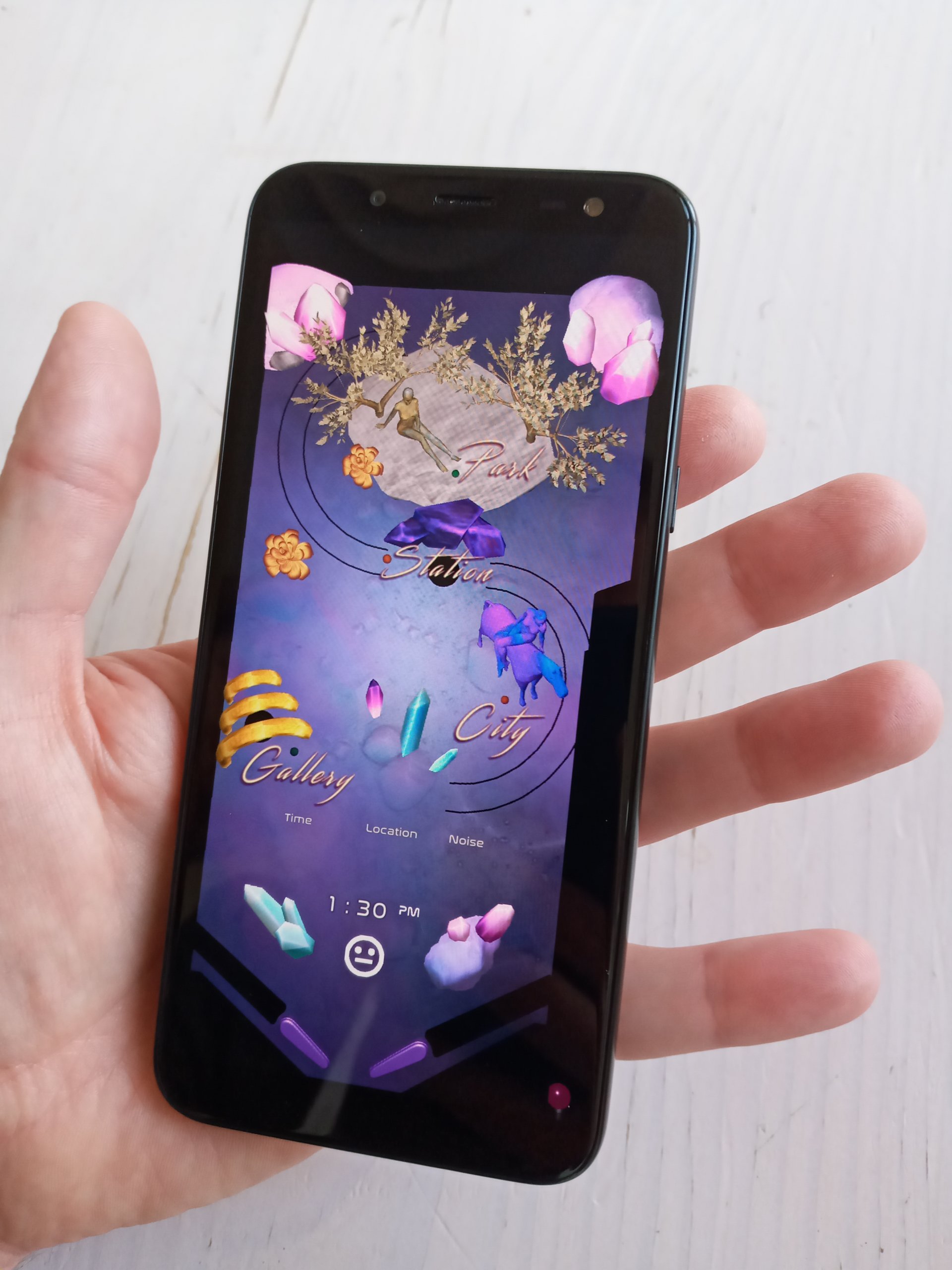 Photo of hand holding a mobile phone with a pink and purple Mood Pinball app displayed