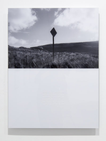 balck and white photo of sign in countryside landscape