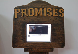 Photo of The Promises Machione a wooden display with embedded screen