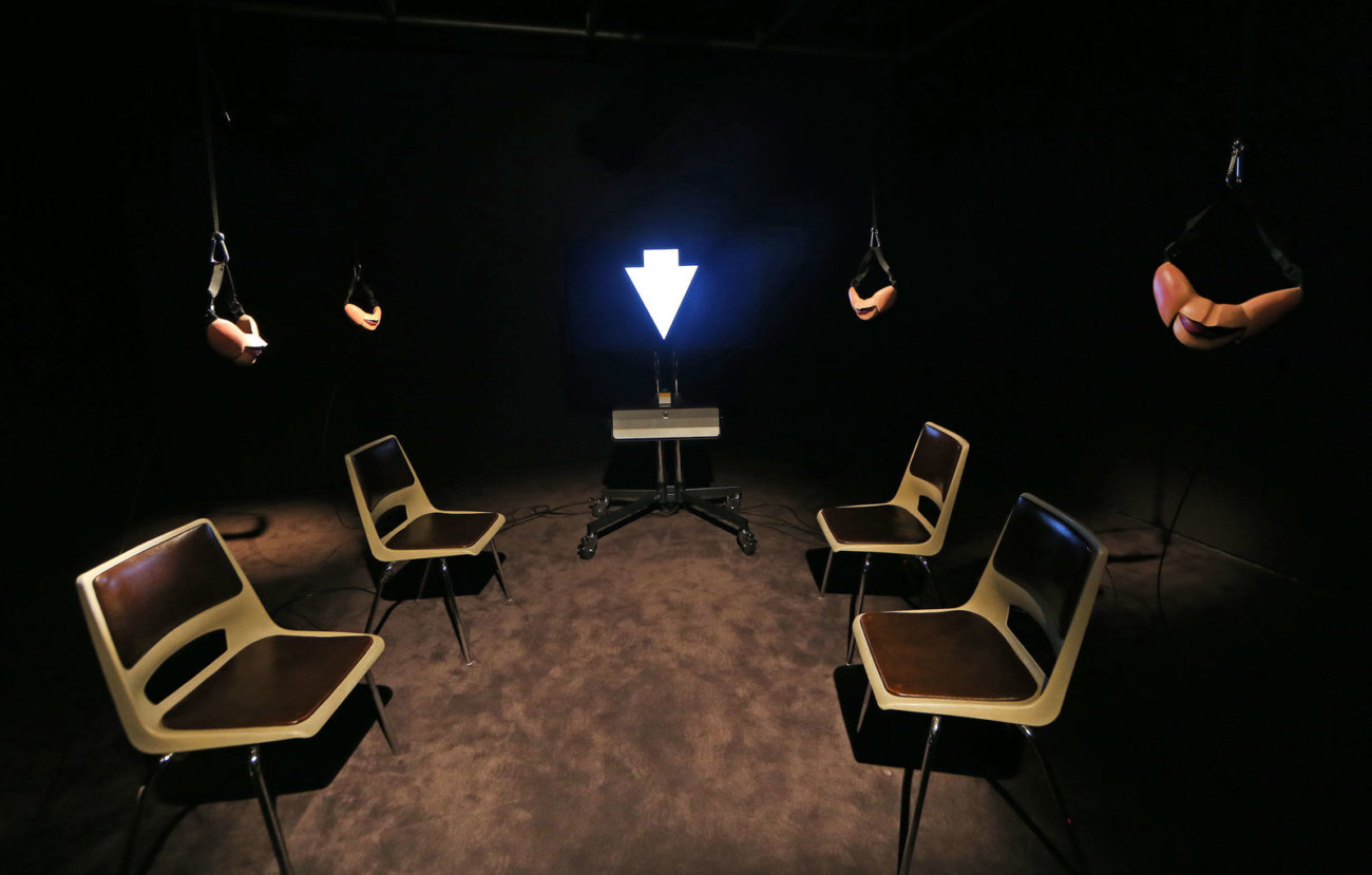 image of a screen with four chairs each with a ventriloquists half-masks hanging above each