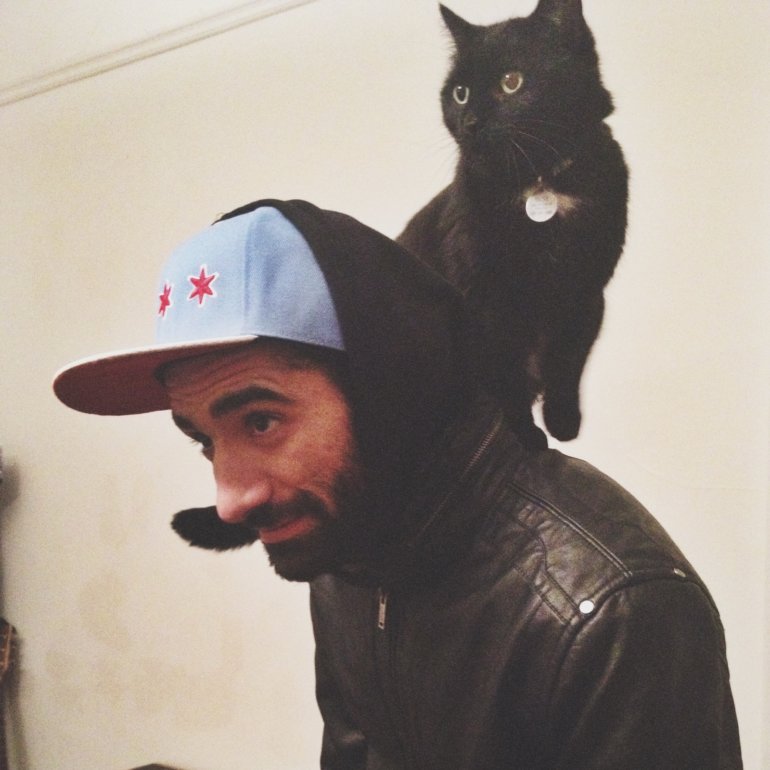 Phot of Nick Briz with black cat on their shoulders